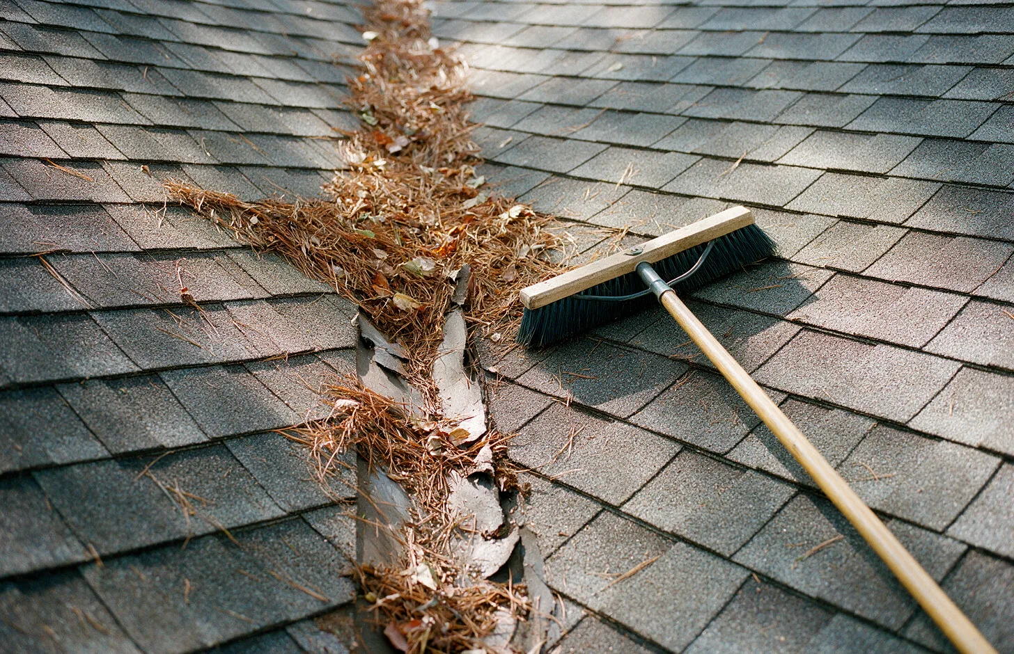 A worn roof valley with debris